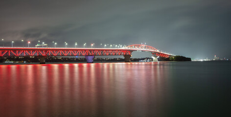 Red lights glow on Auckland Harbour Bridge in support of annual Poppy Day. - 789140392