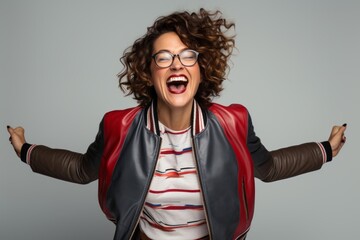 Portrait of a joyful woman in her 40s sporting a stylish varsity jacket in front of plain white digital canvas