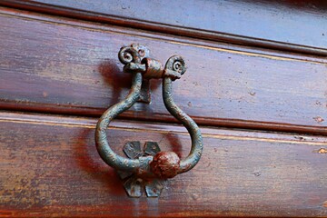 Old rusty handle on a wooden door