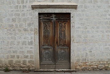 Fototapeta na wymiar Old wooden door in an ancient stone house