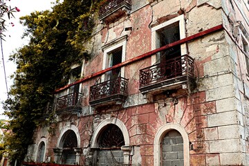 Ancient abandoned, crumbling stone house with openwork balconies
