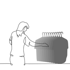 A woman stands in front of the counter, choosing from T-shirts hanging on hangers - one line art vector. concept woman buying a t-shirt in a store