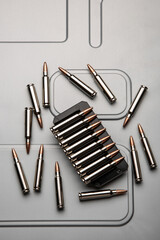 .223 caliber cartridges in silver cases on brushed metal. Ammunition for weapons. Light back