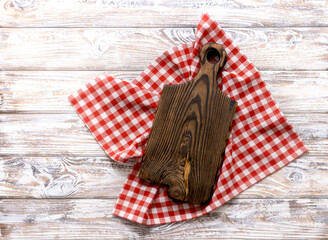 Cutting chopping brown wooden board decorated with red picnic checkered cloth top view. Empty timber,plank. Dish plate advertisement design.