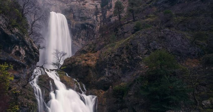 Close up detaul shot Timelapse of beautiful waterfall and rocky mountain in Riopar, Albacete, Spain. Nacimiento del Rio Mundo reventon source river on a cloudy misty spring day