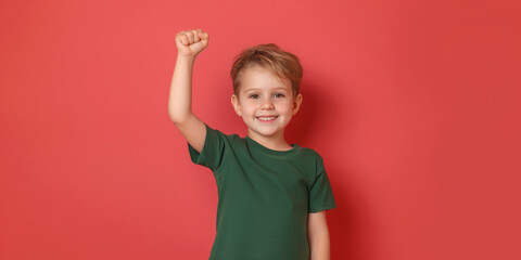 Full body little small fun happy boy 6-7 years old wearing green t-shirt do winner's gesture clenched fist isolated on on Coral color background