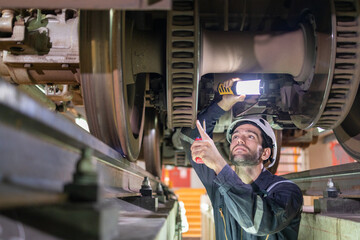 Railway technicians inspect the suspension brakes and axle stability control systems of electric...