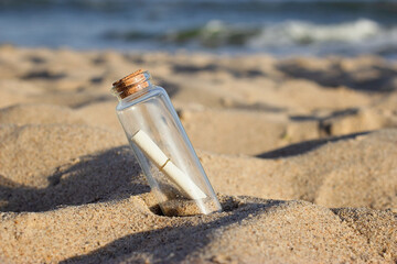 a message in a bottle is buried in the sand on the beach