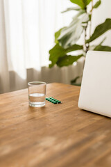 pill packet and a glass of water on the table