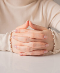 close up of a woman holding her hands on the table, nails and manicure