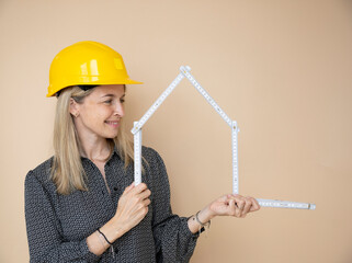 woman, architect, technician, builder, polisher with yellow safety hat and yellow folding rule in front of brown background