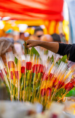 Florist's hand arranging a bouquet of roses at a flower and book stall in a traditional Catalan...