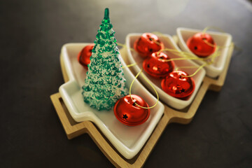 Christmas background. Dish in the shape of a Christmas tree with balls decorations on the table.