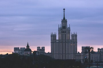 Dawn breaks over Moscow, casting a soft glow on the classic Stalinist architecture of a high-rise...