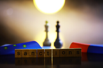 Word Sanctions made of wooden block letters with dramatic lighting and smoke