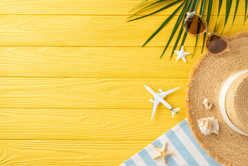 Embrace summer with a top view scene: straw hat, sunglasses, airplane model, beach blanket, palm...