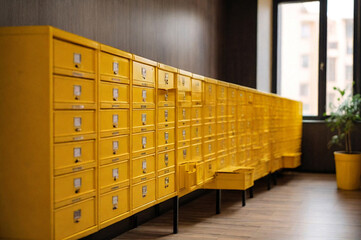 Yellow steel Mailboxes in an apartment residential building inside. Modern rows of numbered mailbox, creative design mail backgrounds. Urban correspondence concept. Copy ad text space. Generated Ai