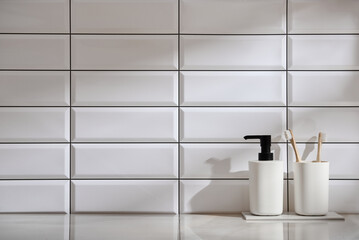 Marble shelf in the bathroom with various objects against a background of white tiles