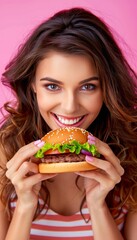 Woman enjoying tasty burger in portrait on soft color background with room for text