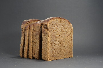 Slices of Black Lithuanian rye bread in black bacground.