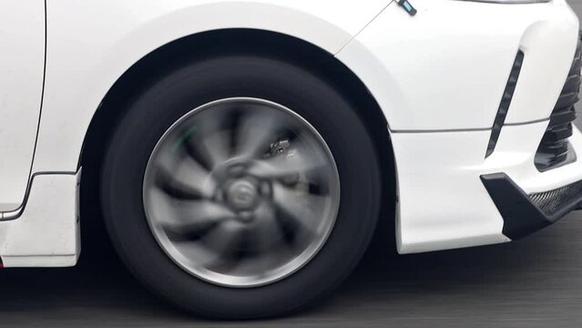 A close up view of the front wheel of a car ride at road