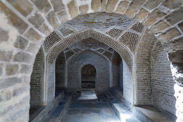 Historical hammam in Bukhara. Arched brick corridors, cool tones, evoking historical depth....