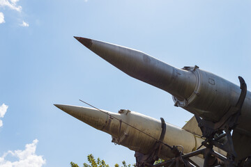 Two anti-aircraft missiles on sky background. Old soviet rocket launcher with two missiles mounted...