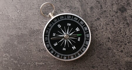 One compass on grey table, top view