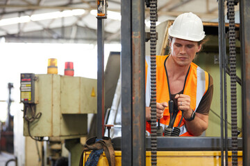 male factory worker control and holding steering wheel on forklift truck