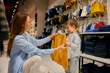 Loving mother and little son doing purchases in shopping mall - 789226357