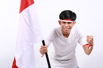Indonesian youth full of enthusiasm carrying the flag while clenching his fists