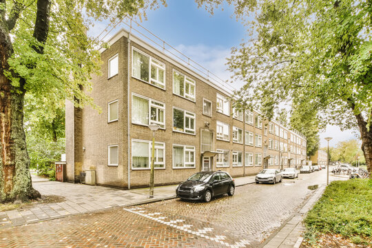 Residential street with brick apartment buildings and parked cars
