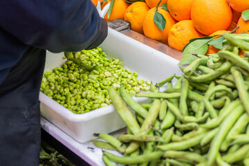 Fresh green beans and oranges at a local market