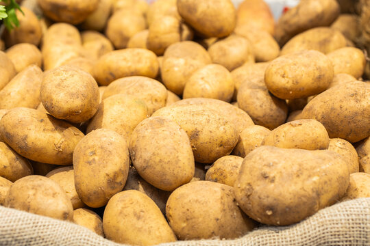 Fresh unpeeled potatoes on display at market