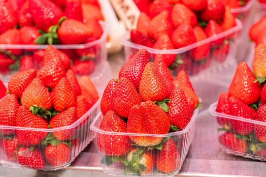 Fresh strawberries in plastic containers at market