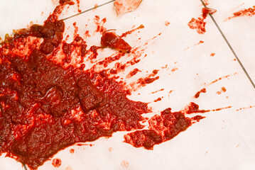 Spilled tomato juice on the floor after breaking a glass jar. Relationship crisis and breakup concept