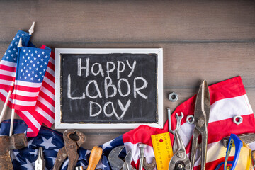 American National Patriotic Workers Happy Labor day Holiday background. Construction and manufacturing tools on wooden background with stars, red white blue striped US flag