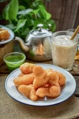 Chinese Doughnut and Pandan Custard with milk tea,Youtiao, chinese bread stick, Thai called Patongko, The background is a retro Thai style cafe