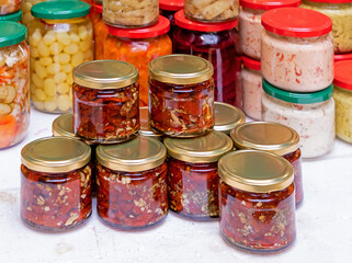 Homemade pickled vegetables prepared food in glass jars sold on market stall