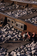 vertical image of railway track section with bolts and stones under lying lines at woodbridge rail station suffolk uk in 2003. closeup view.