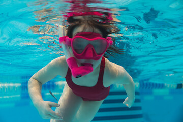 6 year old girl child is engaged in scuba diving with a snorkel and mask in the pool. - obrazy, fototapety, plakaty