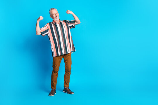 Full length photo of positive nice smiling senior man wear striped stylish clothes empty space isolated on blue color background