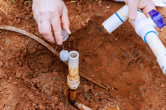 Before gluing pipes together, technician plumbers use clear primer for PVC pipe