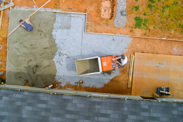 Self dumping track concrete buggy is used to pour wet cement into framework during foundation...