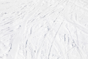 abstract background of white snow with traces of skiers on a sunny day