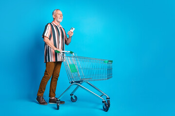 Photo of funny cheerful man wear summer striped stylish clothes walk look empty space isolated on...