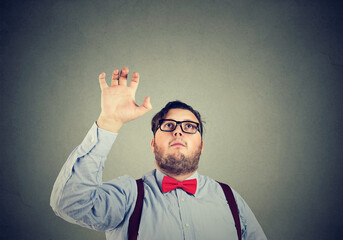 businessman with a raised up hand trying to catch something above