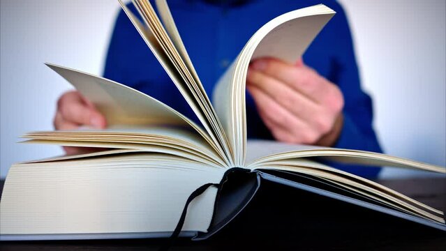 Close-up of a man leafing through a big book