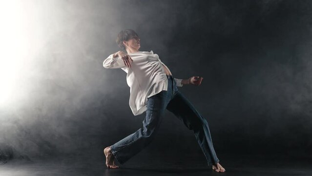 Mature pretty flexible woman performing amazing modern choreography - elegant contemporary style dance in studio.