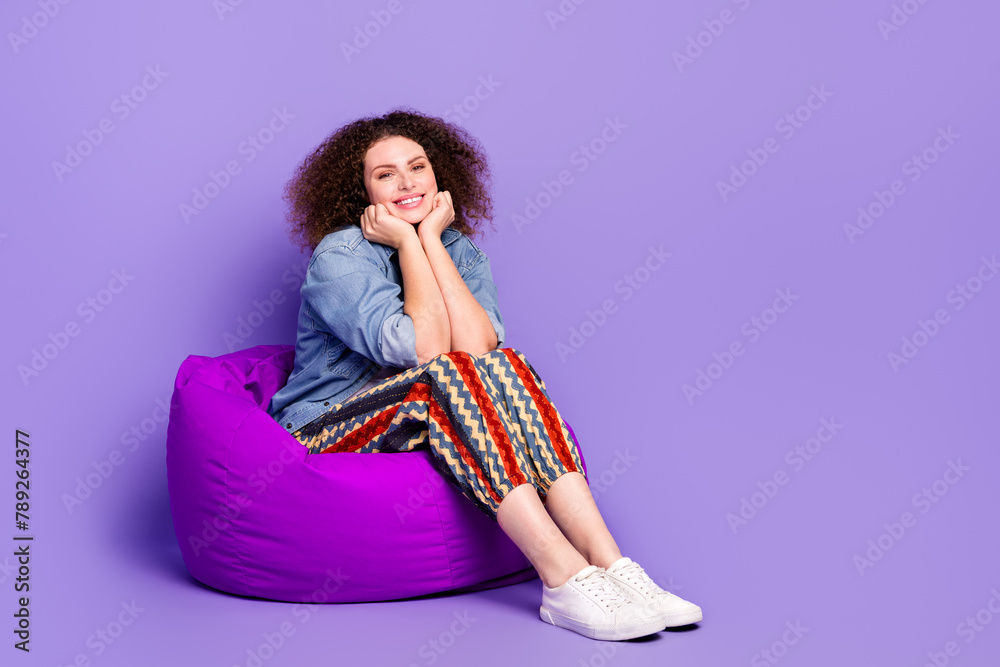 Wall mural Full size photo of cool nice girl sit cozy bag empty space wear denim shirt isolated on violet color background - Wall murals